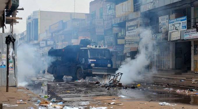 A police water cannon truck clears the remains of burning makeshift roadblocks set by protesters supporting opposition presidential candidate Bobi Wine, in Kampala. CREDIT: Web image