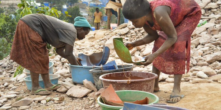 Women work near the Luggingi I mine in Uganda. Many children worked at the mine, often alongside their parents, before a police raid in July forced them to leave. (SOURCE: globalpressjournal.com)